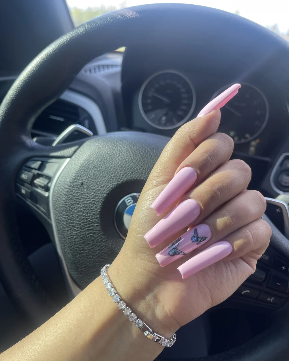 Long pink coffin nail extensions with butterfly art
