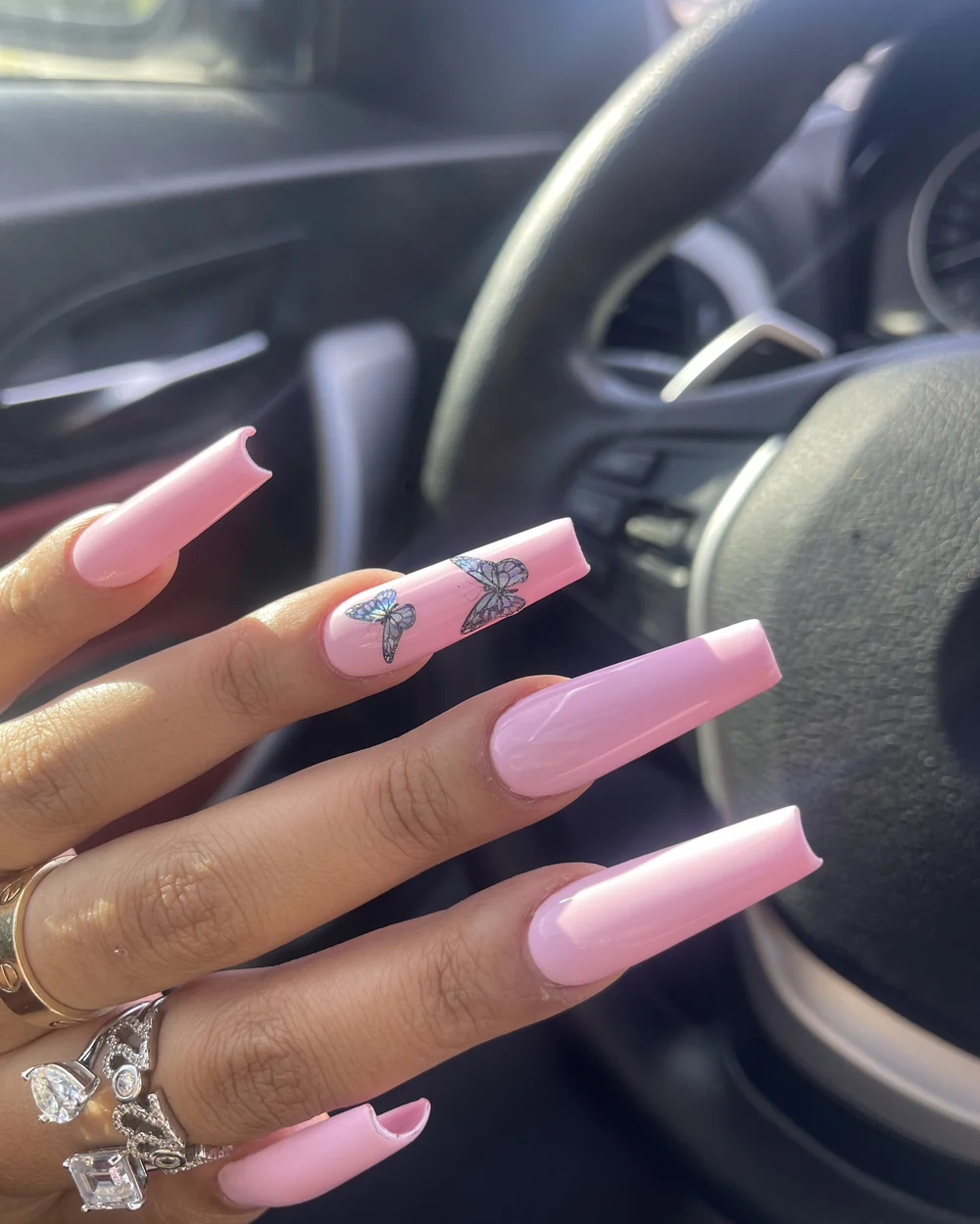 Pink coffin nail extensions with butterfly nail art